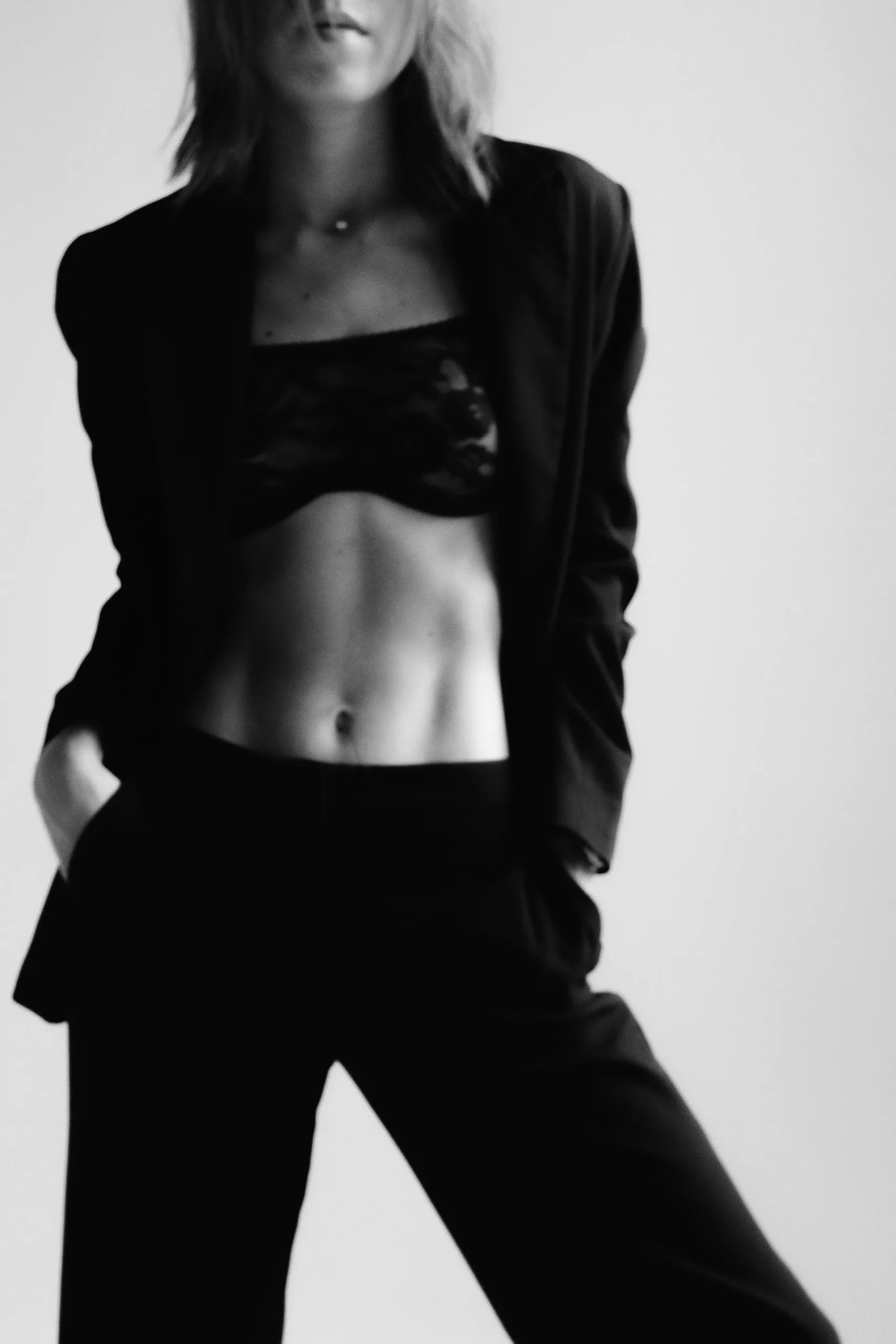 Woman with toned body posing in a black blazer
